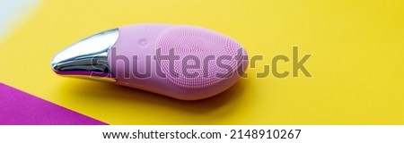 Modern face cleansing brush on bright background. Cosmetic accessory.Beauty and skincare concept. Brush for face lifting, anti-aging wrinkles and massage