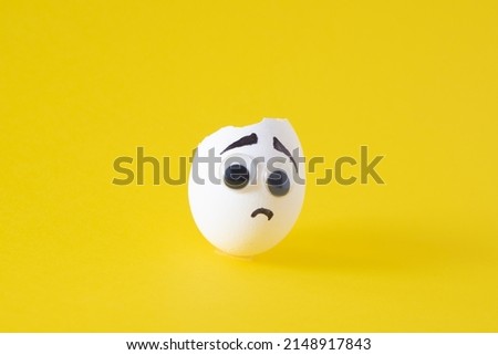 Easter egg idea for kids, seasmless yellow background. Drawing on egg, concerned  and scared face.