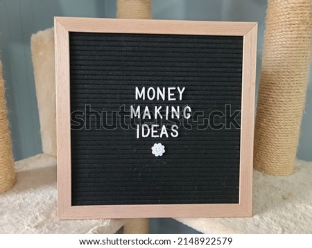 A sign saying money making ideas. The felt sign has removable letters than can be moved around to make whatever words or saying one wants. 