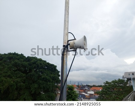 Mini speaker or megaphone mounted on a pole on the roof of a building as a sign for an emergency.
