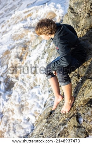 Teenager playing in waves of the ocean shore