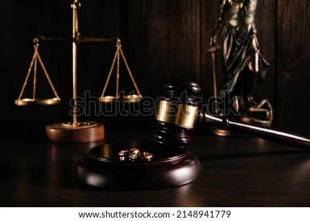 Gold rings on wooden mallet in a courtroom. Divorce concept Royalty-Free Stock Photo #2148941779