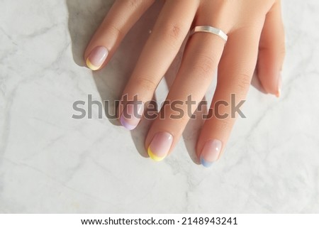 Beautiful womans hand with spring summer nail design on marble gray background Royalty-Free Stock Photo #2148943241