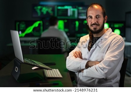 Portrait of happy scientist doctor wearing white coat in the office, looking at camera. Copy space.