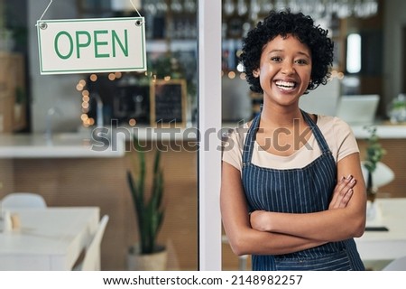Dream big and start small - but most of all, start. Portrait of a young woman standing alongside an open sign in a cafe.