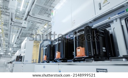 Row of Wafer FOUPs Inside Bright Advanced Semiconductor Production Fab Cleanroom with Working Overhead Wafer Transfer System  Royalty-Free Stock Photo #2148999521