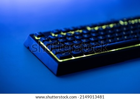 a mechanical gaming computer keyboard with rgb led backlight on the table at night