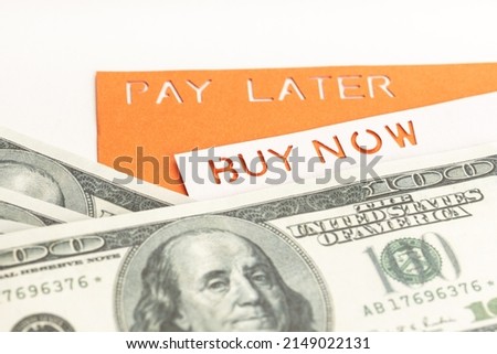 BNPL or Buy Now Pay Later concept. Dollar bills and label with message on white table
