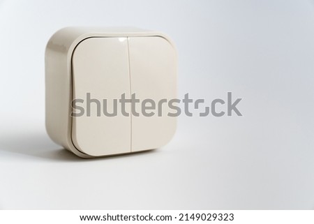 Two-key light switch on a white background. mechanical device for switching the lighting circuit, has two control keys. shop of electronic devices for the home. Royalty-Free Stock Photo #2149029323