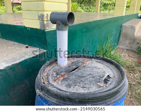Drain pipe PVC gray color with old plastic bucket on the outdoor