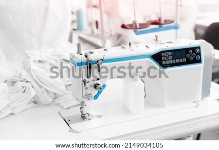 Closeup sewing machine with thread, background white color sun light. Concept Interior of garment factory.