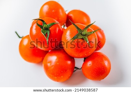 Bunch of ripe tomatoes with one source of natural light. Ripe tomatoes on vine. Ripe red tomatoes in water drops Royalty-Free Stock Photo #2149038587