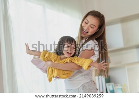 Mother having fun and playing with her daughter at home, Happy Asian little child, family concept