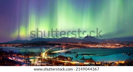 Aurora borealis or Northern lights in the sky over Tromso with Sandnessundet Bridge - Tromso, Norway Royalty-Free Stock Photo #2149044367