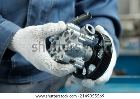 Repair and maintenance of the car in the service center.Spare parts. Power steering pump. Royalty-Free Stock Photo #2149055569