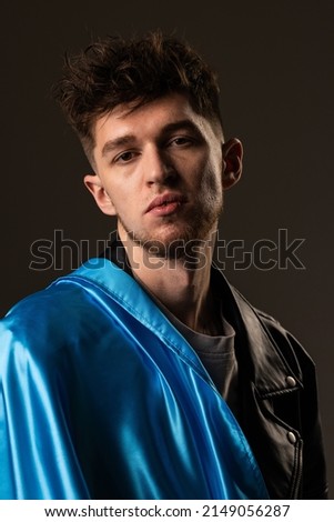 Happy young man with Ukrainian flag on dark background