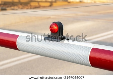 Simple rail crossing barrier red light, train crossing railroad station gate detail, closeup. Warning signal light on, object up close, nobody, no people. Rail transportation safety, rail transport Royalty-Free Stock Photo #2149066007
