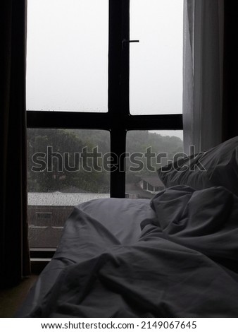 Drops on the window pane in a room on a rainy background