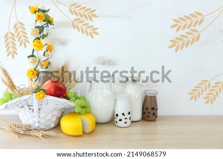 Photo of dairy products over wooden table. Symbols of jewish holiday - Shavuot