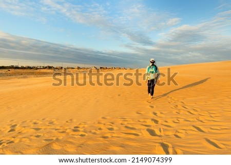 A young tourist hiking on sand dune at Jockey's Ridge State Park , Nags Head, North Carolina USA.  Royalty-Free Stock Photo #2149074399