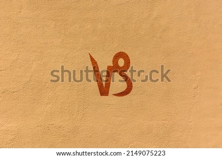 shot of a zodiac sign drawn on a yellow wall, the specific sign is Capricorn