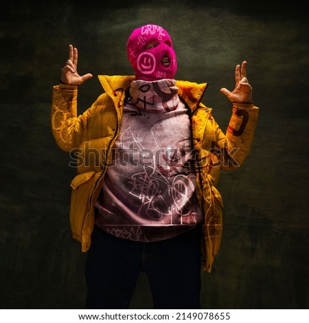 Contemporary art collage. Creative design. Stylish man in pink balaclava isolated over textured dark green background. Retro and modern style. Concept of street art, creativity, youth, fashion Royalty-Free Stock Photo #2149078655