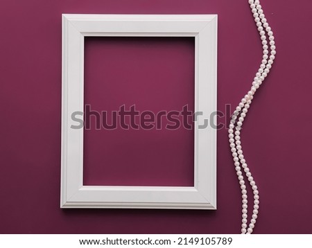White vertical art frame and pearl jewellery on purple background as flatlay design, artwork print or photo album concept