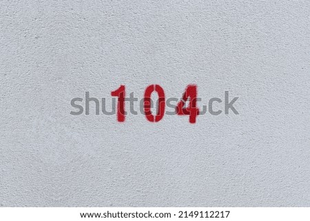 RED Number 104 on the white wall. Spray paint. 
