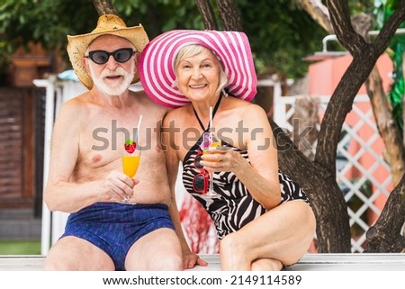 Happy senior couple having party in the swimming pool - Elderly friends releaxing at a pool party during summer vacation Royalty-Free Stock Photo #2149114589