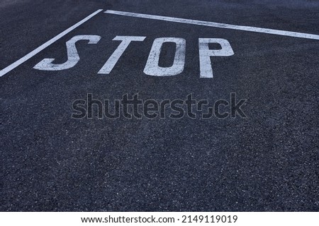 detail of a white stop sign painted on the pavement