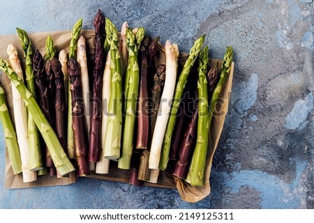 Green, white and purple asparagus on a kitchen background Royalty-Free Stock Photo #2149125311