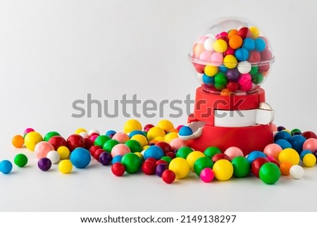A plastic toy gum ball machine with colourful gum balls all around. Royalty-Free Stock Photo #2149138297