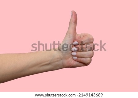 A woman's hand raises her thumb up. Symbol of good mood.