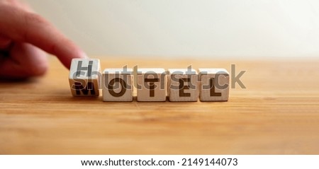 Hotel or motel concept. Hand flips letter on wooden cube changing the word hotel to motel. Message for room rent, tourism accommodation, luxury lodging. Royalty-Free Stock Photo #2149144073