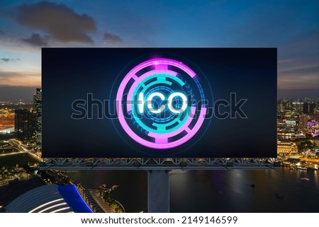 ICO hologram icon on billboard over panorama city view of Singapore at night time. The hub of blockchain projects in Southeast Asia. The concept of initial coin offering, decentralized finance