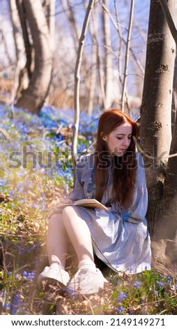 A girl is drawing in the meadow