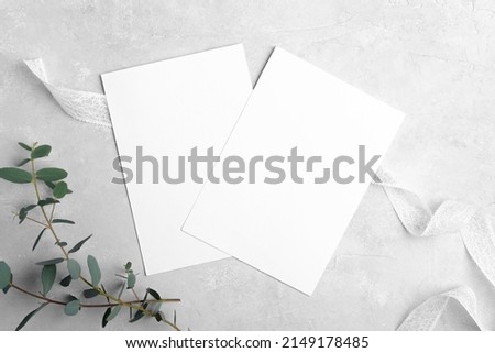 Two wedding stationery invitation cards mockup 5x7 on neutral grey background with eucalyptus leaves, bridal shower mockup Minimal blank card mockup, thank you card, greeting card Royalty-Free Stock Photo #2149178485