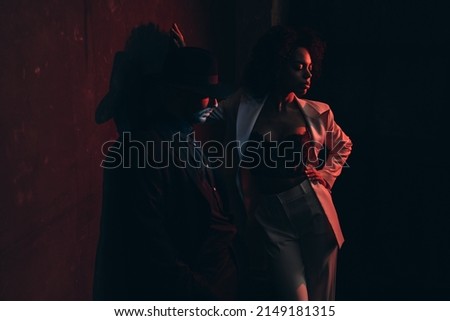 Two dynamic teenagers in posh attire performing vogue dance in loft studio, apartment or night club lit by pink and blue neon lights.  Royalty-Free Stock Photo #2149181315