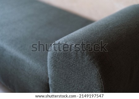 Selective focus on upholstery of new couch. Cleaning service, repair and restoration furniture concept. Close up view of green textile on comfortable sofa or armchair in apartment Royalty-Free Stock Photo #2149197547
