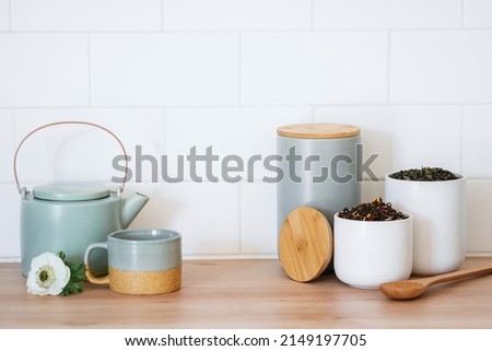 Natural rooibos tea, organic drink, detox or weight loss beverage concept. Kitchen table with teapot, cup and organizer storage box or container for herbs. Enjoying morning at home Royalty-Free Stock Photo #2149197705