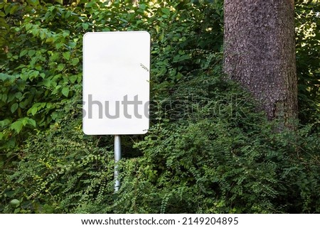 Empty blank sign board on a pole in a forest