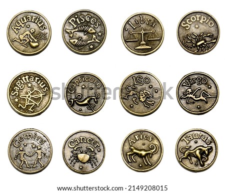 Twelve coins with signs of the zodiac. Isolated on white background
