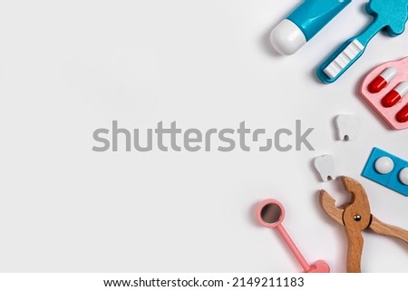 Banner with teeth cleaning and treatment tools. Oral hygiene concept. Toothbrush, toothpaste, pills, dental forceps and mirror. Children game at dentist. Copy space. High quality photo