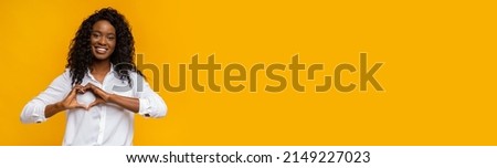 Wide Banner With Friendly Black Woman Shaping Hands Like Heart, Smiling African American Female Making Love Gesture, Expressing Kindness While Posing On Yellow Background, Long Shot, Copy Space