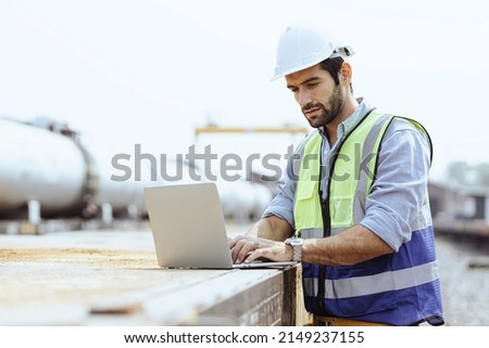 Heavy-duty industrial engineers stand in a pipeline manufacturing facility using digital tablet computers for the construction of products to transport oil, gas and fuel. Royalty-Free Stock Photo #2149237155