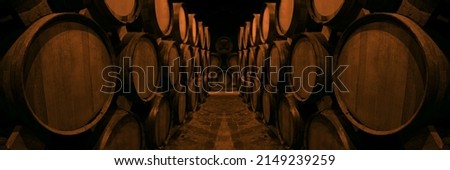 Wine or cognac barrels in the cellar of the winery, Wooden wine barrels in perspective. wine vaults. vintage oak barrels of craft beer or brandy.  Royalty-Free Stock Photo #2149239259
