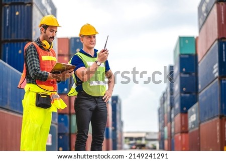 Professional engineer container cargo foreman team in helmets working standing and using walkie talkie checking stock into container for loading.logistic transport and business industry export