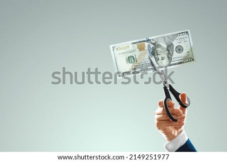 One hundred dollars bill is cut with scissors in the hand of a businessman. Business concept, income reduction, economic crisis, default, mortgage, loan, debt. copy space Royalty-Free Stock Photo #2149251977