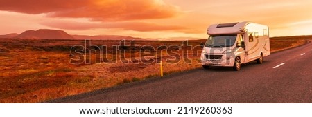 Motorhome camper van RV road trip. People on travel vacation adventure. Tourists in rental car campervan by view of mountains in beautiful nature landscape at sunset Royalty-Free Stock Photo #2149260363