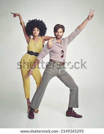 Lets dance. An attractive young couple standing together in retro 70s clothing. Royalty-Free Stock Photo #2149265293